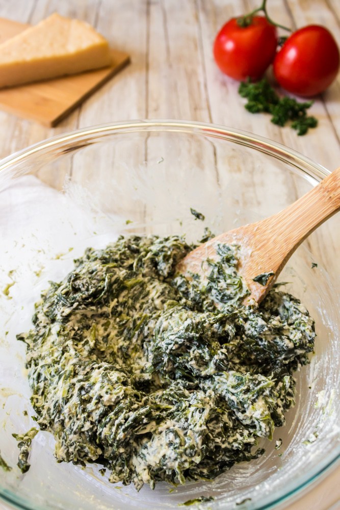 Bowl of ricotta cheese and chopped spinach.