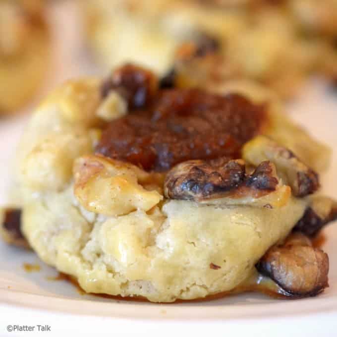 Pumpkin butter thumbprint cookie garnished with crusted walnuts.