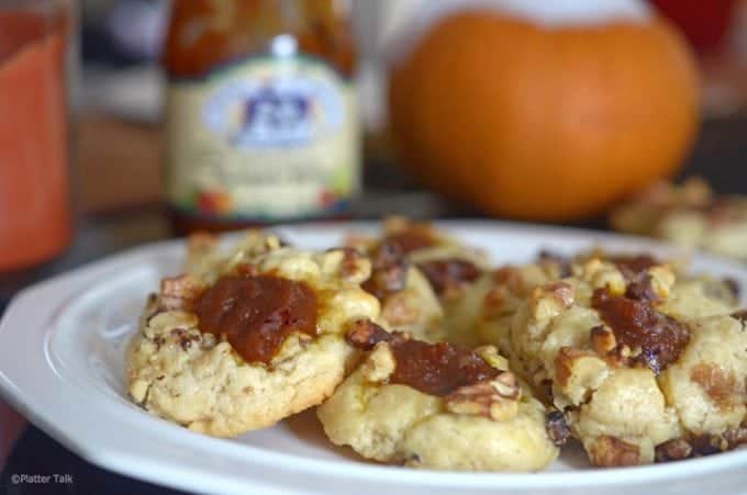 Plate of pumkin cookies with a pumpkin in the background.