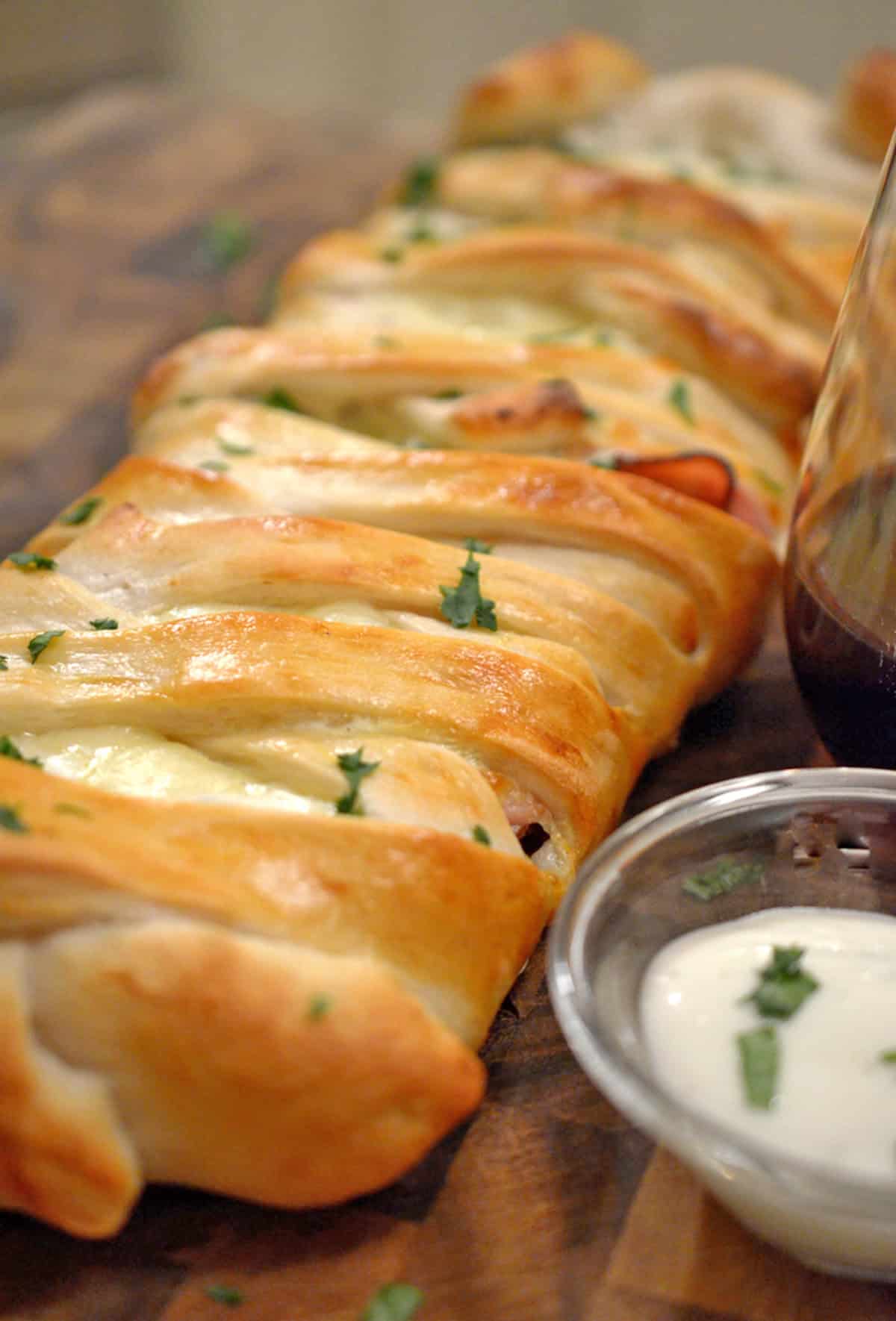 A freshly baked stromboli with dipping sauce.
