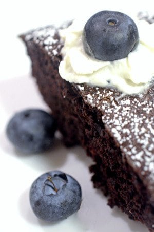 A close up of a slice of chocolate cake with whipped cream