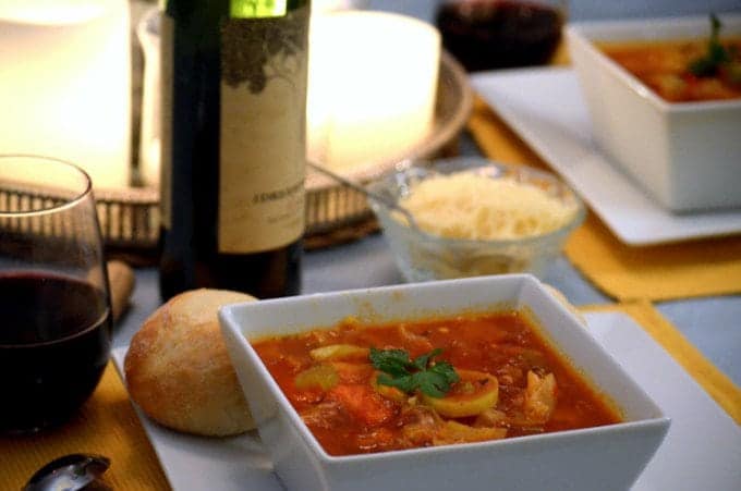 A close up of a bowl of food on a table, with Soup