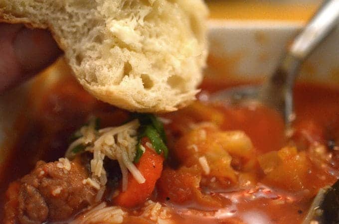 Dipping bread into a bowl of soup.