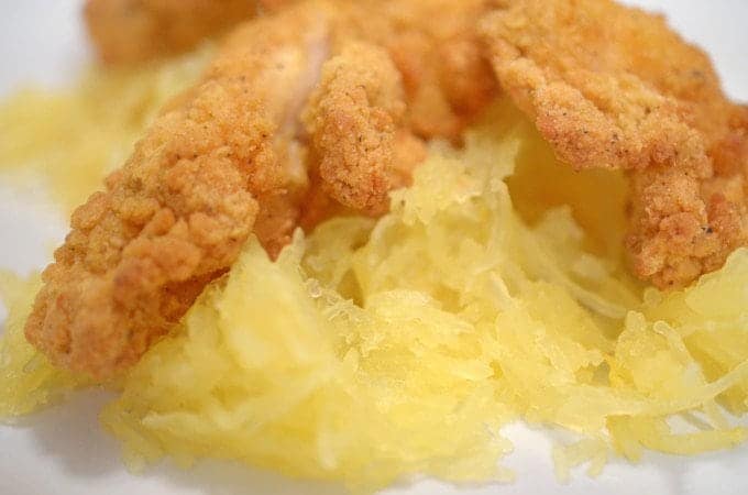 A close up of a plate of food, with chicken strips