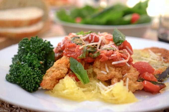 A close up of a plate of food with chicken and spaghetti squash