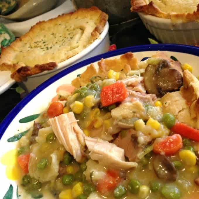 A plate of food with rice and vegetables, with pot pies in the background.