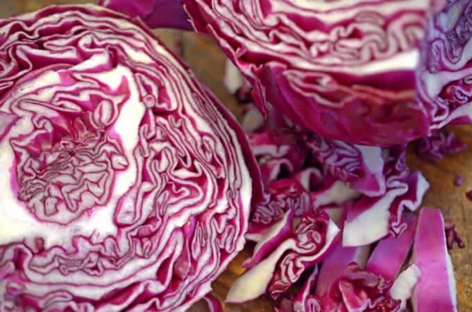 Raw head of red cabbage cut on bias on board