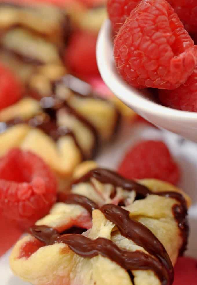 A close-up of some dessert and raspberries.