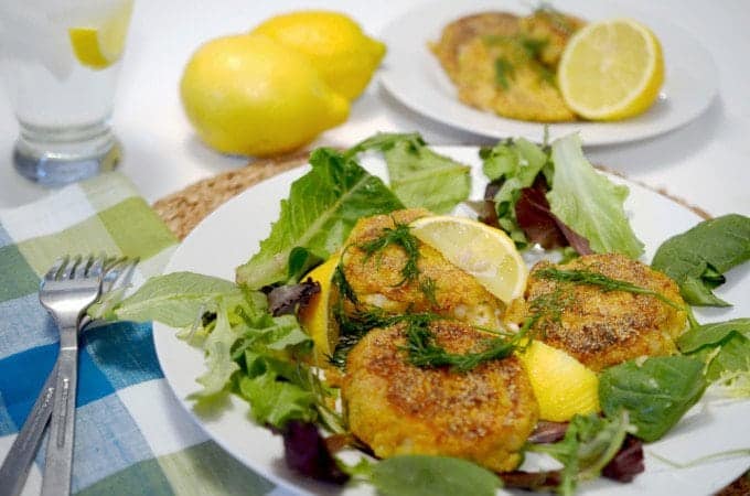 A plate of fish cakes sitting on a bed of lettuce.