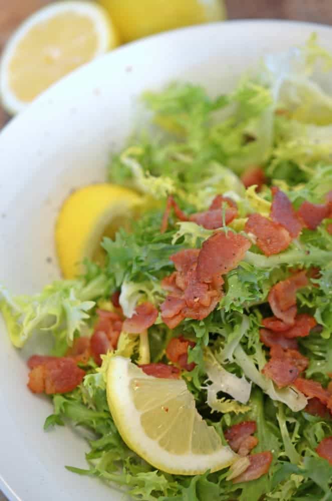 A dish of lettuce with chopped bacon.