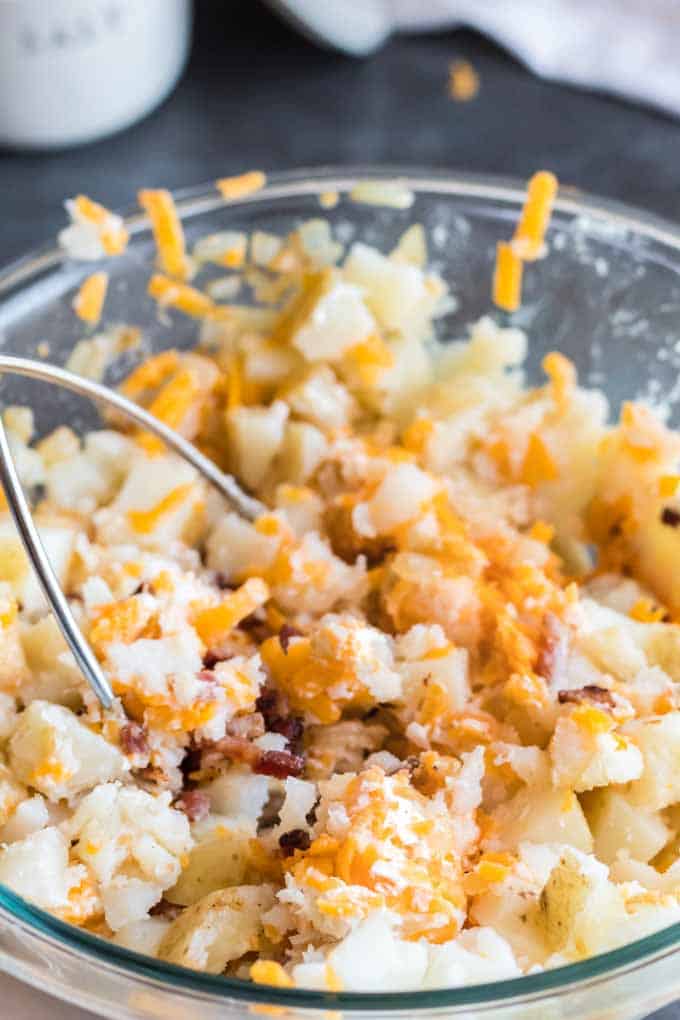 Mixing potatos and shredded cheese for pierogi filling.