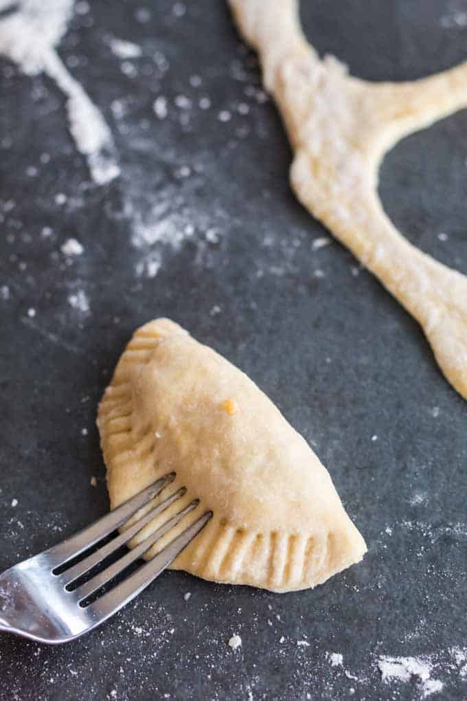 Crimping pierogi edges with a fork.