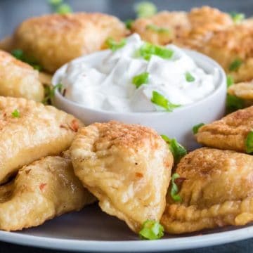 tray of pierogi with sour cream.