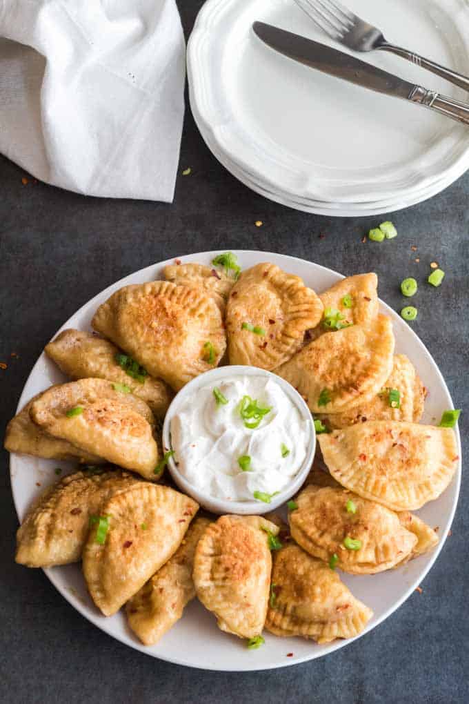 Plate of Pierogi with sour cream.