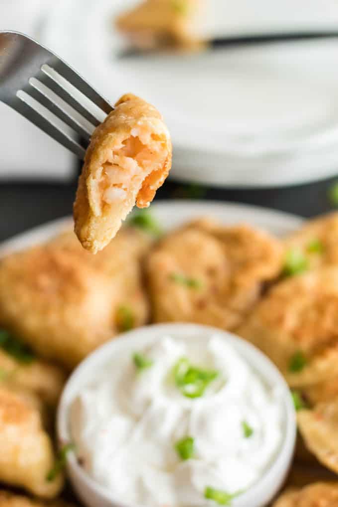 Polish pierogi cut in half and dipped in sour cream.