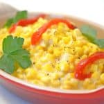 A bowl of corn on a plate.