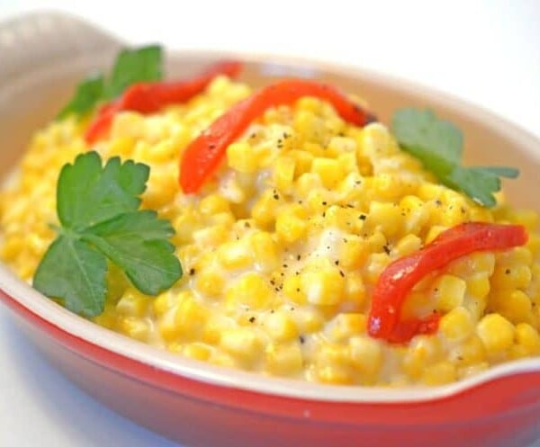 A bowl of corn on a plate.