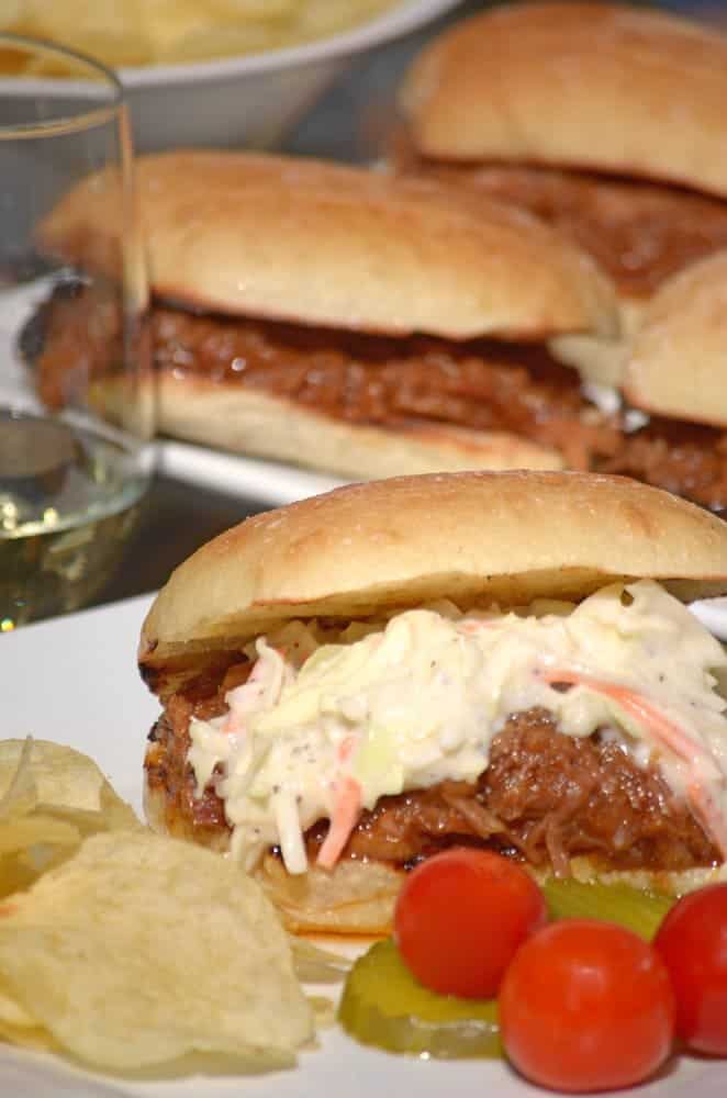 A bunch of sandwiches topped with cole slaw.