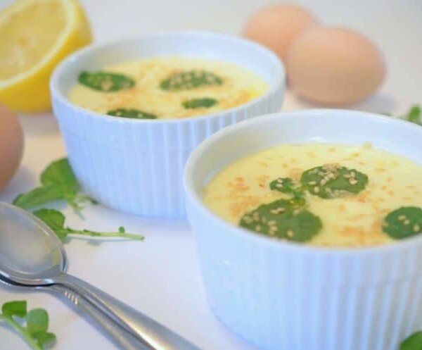 two bowls of soup with eggs in the background.