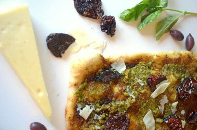 A plate of food, with Pizza and Pesto.