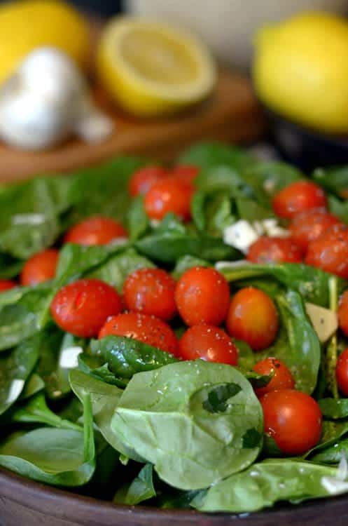 A plate is filled with fresh fruit and vegetables, with Spinach on a platter.