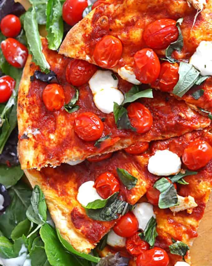 A plate of food, with Pizza and Tomato