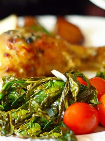 A plate of food with meat and vegetables, with Spinach and Chicken