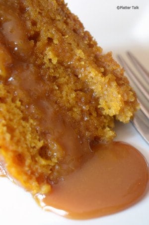 A close up of a piece of cake on a plate with caramel sauce