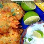Corn fritters with bowl of avocado cream and limes.