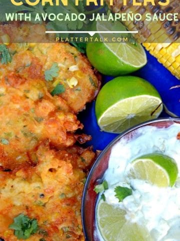 Corn fritters with bowl of avocado cream and limes.