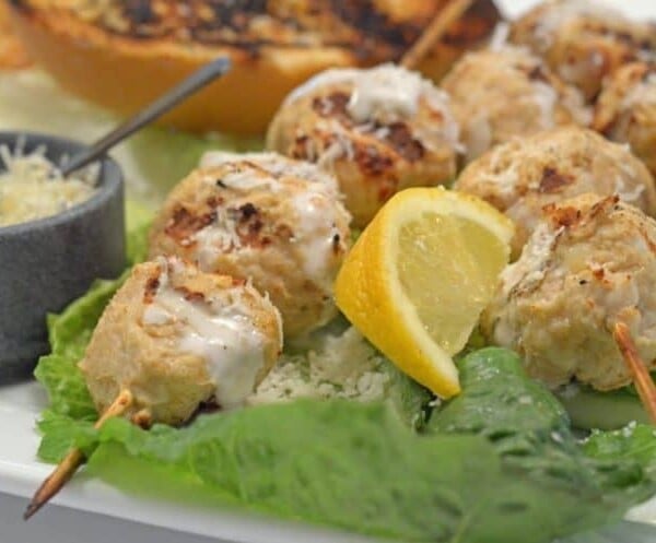 Chicken caesar kebabs on a bed of lettuce.