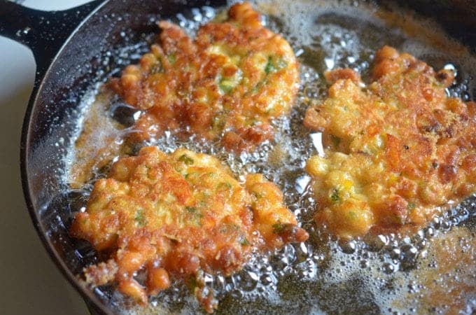 Corn fritters frying in a skillet