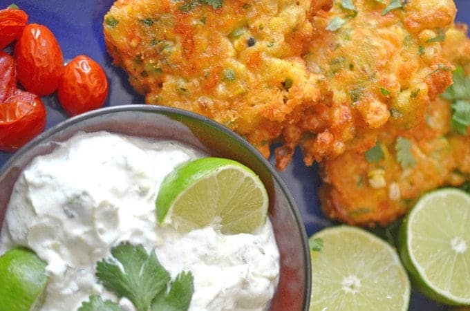 A plate of food, with corn fritters and dipping sauce