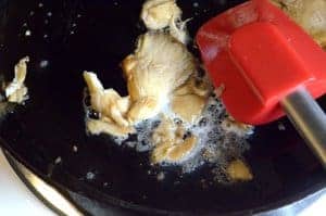 Stirring a big mushroom in a skillet.