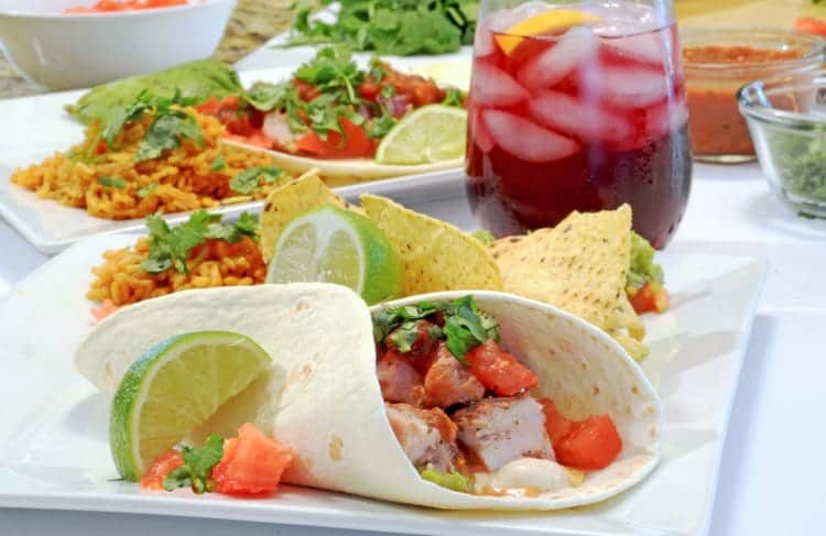 A plate of tacos with a drink.