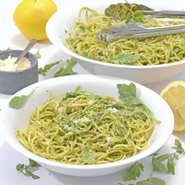 A bowl of food on a table, with Pesto and Arugula
