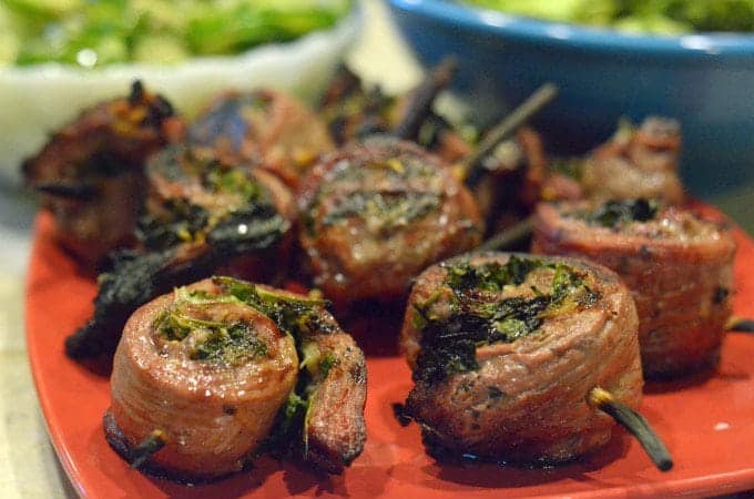 A plate of grilled flank steak pinwheels on a red platter