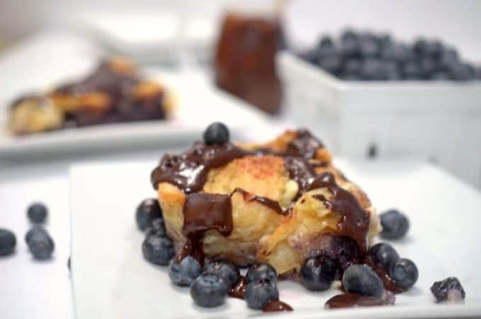 A close up of blueberry bread pudding on a plate.