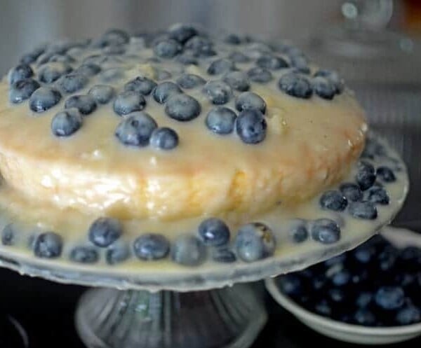 A blueberry cake on a stand.