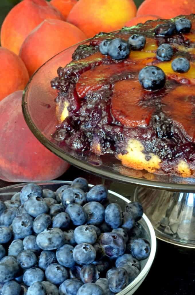 A close up of a cake and a bowl of blueberries