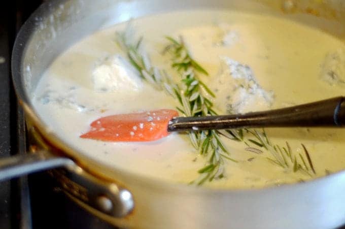 a pan of sauce with a sprigg of rosemary