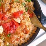 A skillet with a wooden spoon with Jambalaya and Sausage