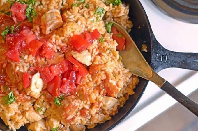 A skillet with a wooden spoon with Jambalaya and Sausage