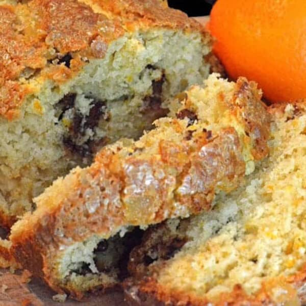 A loaf of orange bread being sliced.