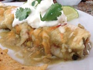 A close up of a plate of food, with Enchilada and Chicken