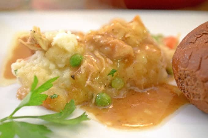 A close up of a plate of food, with Shepherds pie and gravy