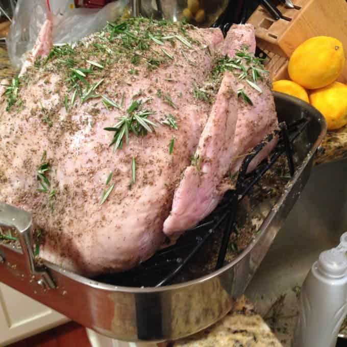 An uncooked turkey in a roasting pan