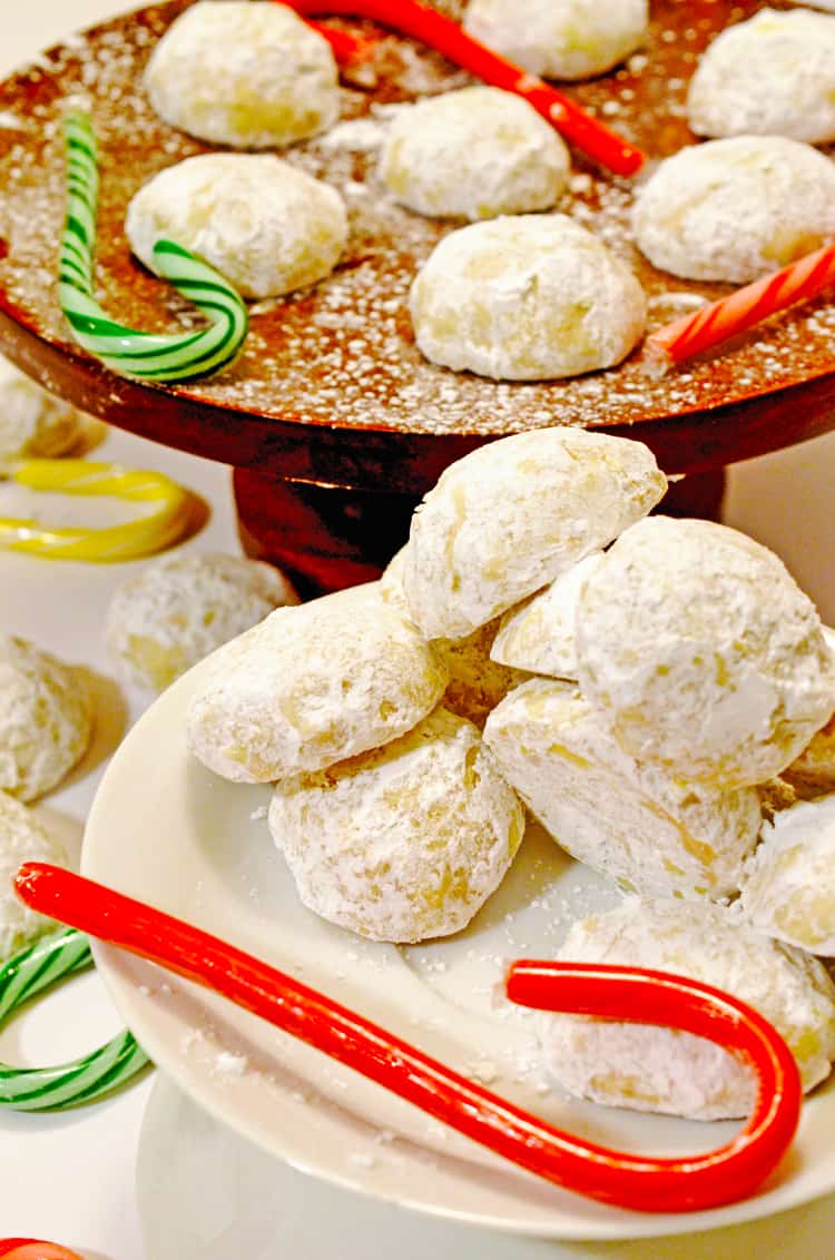 Plate of snowball Christmas cookies with candy canes.