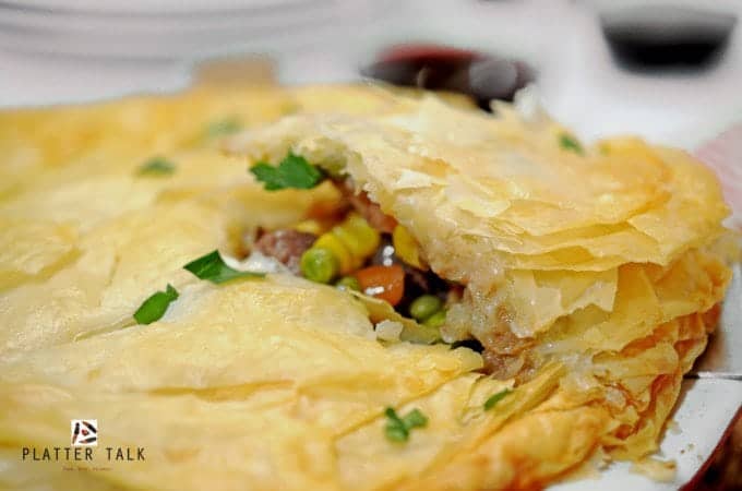 A wedge of beef pot pie being served