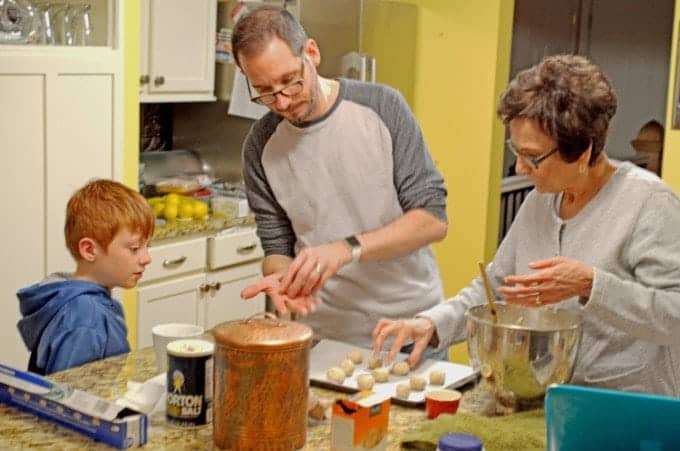 Young boy with father and grandmother, making Christmas cookies.